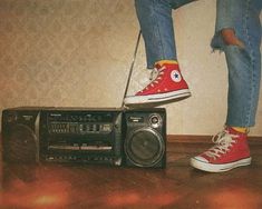 a person standing on top of a radio next to a boombox