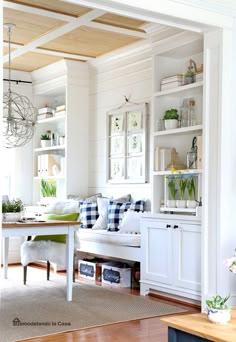 a living room filled with furniture and lots of white shelves on top of each other