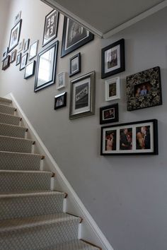 a staircase with pictures on the wall and framed photos on the wall above it's handrail