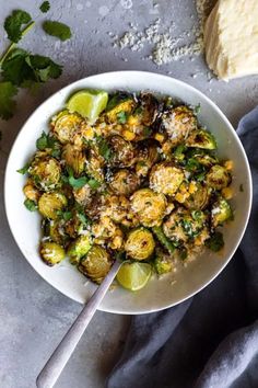 a white bowl filled with brussel sprouts and topped with parmesan cheese