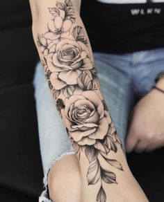 a woman's arm with roses and leaves on it