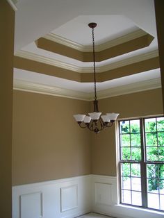 a chandelier hangs from the ceiling in an empty room