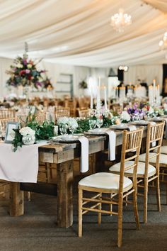 the tables are set up with white linens and greenery for an elegant wedding reception