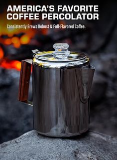 an american's favorite coffee percolator sits on a rock next to a fire