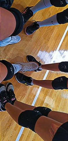 there are many people standing on the basketball court with their feet up and shoes down