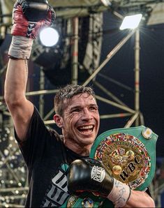 a man holding up a boxing glove in the air