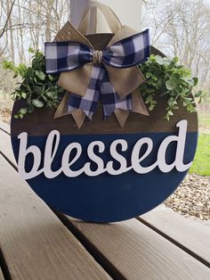 a wooden sign that says, blessed on it with a bow hanging from the front