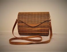 Our wooden bag's is made from 3,5mm (1.4 Inch) Palisander Rio veneer and plywood. Wooden Bag is simply transferable to clutch bag. The bag handle (genuine leather strap) is simply removable from bag and you can put in the bag. These unique bags are treated against moisture, so a little rain will not damage it. External size: -Width: 8.9 Inch (22.6cm); -Height: 6.9 Inch (17.5cm) (without handle); -Depth: 3.9 Inch (10cm); Internal size: -Width: 8.4 Inch (21.3cm); -Height: 6.5 Inch (16.5cm) -Depth: Natural Shoulder Bag With Bamboo Handle As Gift, Eco-friendly Brown Clutch Shoulder Bag, Natural Color Clutch Shoulder Bag As Gift, Natural Color Clutch Shoulder Bag Gift, Natural Color Clutch Shoulder Bag For Gifts, Wooden Handbag, Wooden Clutch, Wood Purse, Modern Clutch