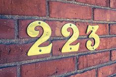 a brick wall with numbers on it and the number twenty - two in yellow painted metal