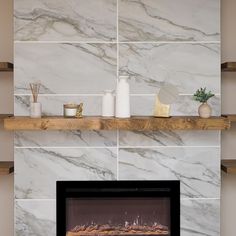 a fireplace with white marble walls and shelves