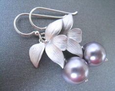 Silver flowers let moody lavender crystal pearls gracefully dangle. Other luscious pearl colors are available.These Earrings are perfect for bridesmaids gifts.This pair pictured has the lavender pearls and wire #4.Rose Gold and Gold are also available.The total earring measures 1 1/8" with the wire in the first picture. Other wires are available and represented in the last picture. Please choose wire selection at checkout. Elegant Lavender Flower Earrings For Gift, Elegant Lavender Earrings With Ear Wire, Elegant Lavender Flower Earrings With Ear Wire, Lavender Bridesmaids, Pearl Silver Earrings, Rose Gold Initial Necklace, Lavender Bridesmaid, Rose Gold Initial, Rose Gold Bridesmaid