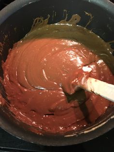 a wooden spoon mixing chocolate in a pot