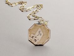 This lovely gold filled vintage/antique locket dates to the Art Deco era (circa - 1930s- 1940s). Featuring a square shape the front of the locket has a beautiful floral design with an Initial "M" in the middle.  It opens from the top to reveal two areas inside in which to place your keepsake photos. The reverse (back) of the locket has a horizontal striped design. It is placed on a gold filled CZ (Cubic Zirconia) bail and is suspended from a handmade gold filled paperclip chain wire wrapped with genuine yellow agate gemstones. Age: Art Deco (1930s-1940s) Measurements: Locket is 1-1/4" in diameter (not including silver built in loop) Necklace is 24" in length with a drop length of 27". Total weight of locket and chain is Condition: In great antique/vintage condition. Minor wear consistent w Art Deco Jewelry With Vintage Charm For Anniversary, Art Deco Vintage Charm Jewelry For Anniversary, Art Deco Wedding Pendant Jewelry, Art Deco Vintage Charm Jewelry As Gift, Art Deco Vintage Charm Jewelry Gift, Art Deco Style Vintage Charm Jewelry Gift, Vintage Octagon Jewelry Gift, Gold Etched Locket Necklace For Wedding, Victorian Etched Necklaces For Weddings