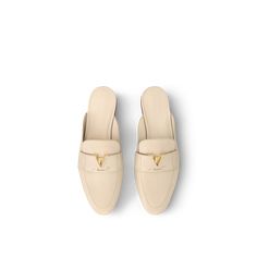 a pair of beige shoes on top of a white surface