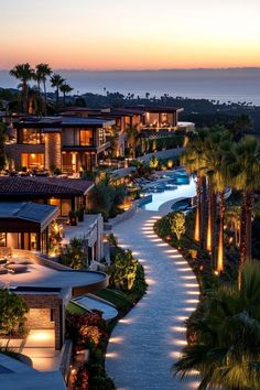 an aerial view of a resort at dusk with palm trees and pool in the foreground