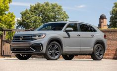 the new volkswagen atlastro is parked in front of a brick wall and gated area