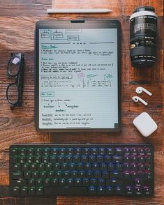 a tablet computer sitting on top of a wooden desk next to a keyboard and mouse