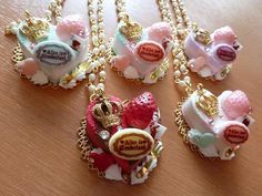 four necklaces with charms attached to them on a table