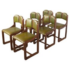 six green leather chairs with wooden frames on each side and one chair in the middle