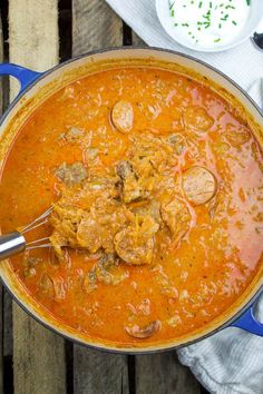 a blue pot filled with food on top of a wooden table