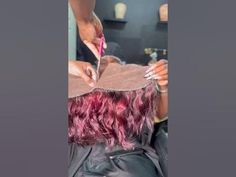 a woman cutting another person's hair with scissors