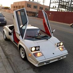 a white car with its doors open on the street