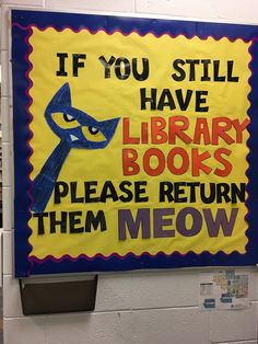 a library sign that reads if you still have library books please return them meow