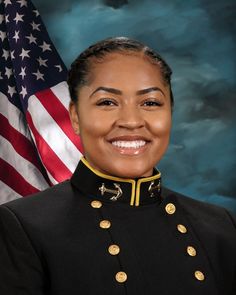 a woman in uniform with an american flag behind her