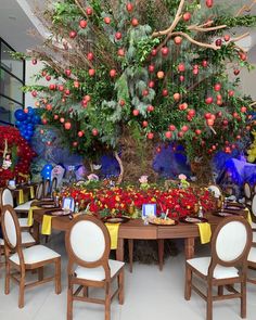 the table is set up for a party with many decorations and fruit on it, including an apple tree