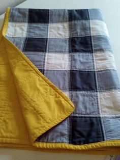 a yellow and gray blanket laying on top of a table