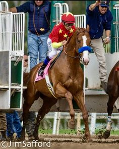 jockeys and their horses running around the track