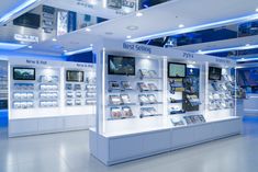 the inside of a store with many electronic devices in display cases and lights on the ceiling