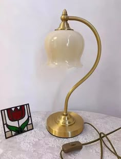 a lamp on a table next to a piece of artwork