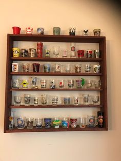 a shelf filled with lots of glasses on top of a wall