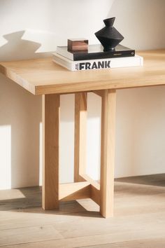 a wooden table with two books on it and a black object sitting on top of it