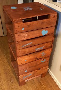 a wooden dresser with blue hearts and stars painted on the drawers, in a kitchen