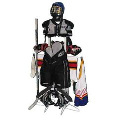 an ice hockey goalie standing next to his uniform and gear on display in front of a white background