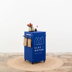 a blue box with some items in it sitting on top of a wooden floor next to a white wall