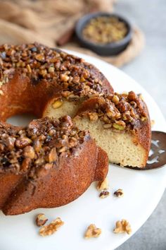 a bundt cake with walnuts and pecans on top is cut in half