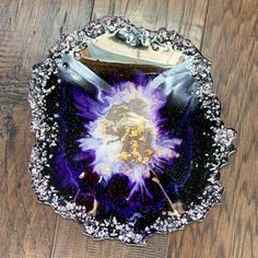 a purple and white plate on top of a wooden table next to a brown floor