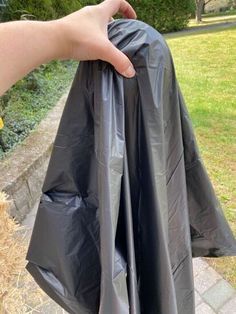 a person holding a black trash bag in their hand