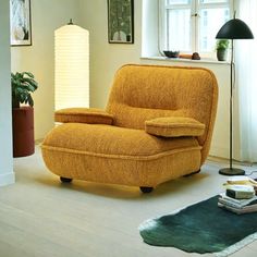 a yellow recliner chair sitting in a living room next to a lamp and rug