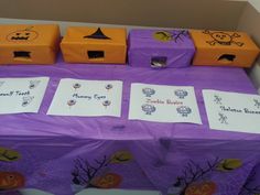 there are many boxes on the table with name tags for each one and two pumpkins