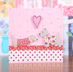 a card with two dogs on it and a heart shaped object in the back ground