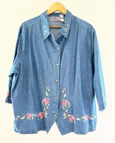 Vintage Bill Blass Women's Jeans Denim Floral Embroidered Denim Button Up Shirt. Boho Country Shirt. Cotton. 3/4 sleeves. Flowers are pinks and greens. No size tag. I would guess it's a 1X or larger. L: 28" underarm to underarm: 27" Check out the rest of our shop: https://instagram.com/hollyshopvintage?igshid=OGQ5ZDc2ODk2ZA== https://hollyshopvintage.etsy.com/ Orders over $35 ship for free. Please check out my Instagram for my newest finds: Hollyshopvintage  Everything priced over $35 has shipping already included in the total price. I'll gladly combine shipping on multiple items to save you money, when it is safe to do so! Message me to make adjustments ahead of time, or make your purchase and I'll refund the shipping overages.  Most items are Vintage. Expect some vintage wear. Items may Spring Medium Wash Shirt With Buttons, Spring Denim Shirt With Snap Buttons, Medium Wash Shirt With Buttons For Spring, Casual Embroidered Button-up Denim Top, Medium Wash Floral Embroidery Button-up Top, Denim Blue Button-up Top With Floral Embroidery, Embroidered Button-up Denim Blue Top, Denim Floral Embroidery Button-up Tops, Embroidered Denim Button-up Shirt