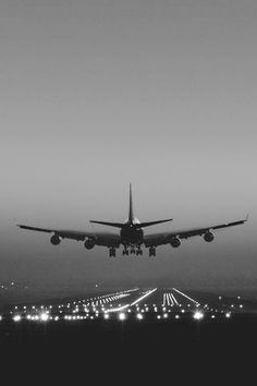 an airplane taking off from the airport runway at night with its landing gear down and lights on