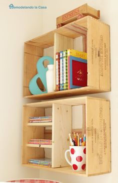 two wooden crates with books and pencils in them on the wall next to a bed