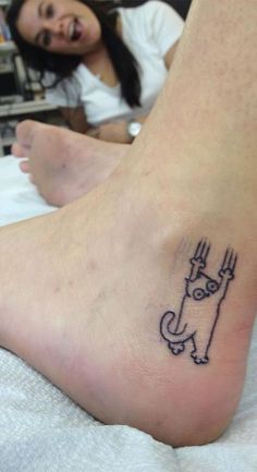 a person with a small tattoo on their foot that has an image of a cat