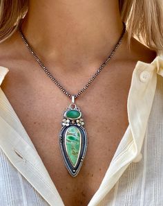 This handmade boho necklace features a stunning green stone pendant crafted from variscite and chrysoprase, set in sterling silver with a nature-inspired design. The customizable chain allows for versatile styling, making this variscite and chrysoprase gemstone jewelry piece a perfect gift for those who appreciate unique, handcrafted accessories.  A Wearable Work of Art ✓ Meticulously handcrafted by skilled metalsmiths using sterling silver, variscite, and chrysoprase ✓ gemstones ✓ Boho-chic design with intricate floral and beaded details, perfect for nature lovers and bohemian fashion enthusiasts ✓ Versatile piece suitable for both everyday wear and special occasions ✓ Customizable chain length (17-21 inches) at no additional cost for the perfect fit ✓ Unique statement piece that makes an Necklace Green Stone, Silversmith Jewelry, Silver Necklace Designs, Silversmithing Jewelry, Silver Smithing, Green Stone Pendant, Boho Necklaces, Green Stone Necklace, Boho Chic Design