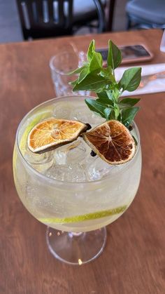 an orange slice is sitting on top of a drink in a glass with ice and garnish